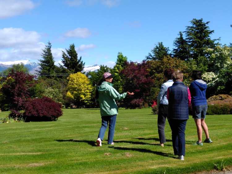 3 guests and a guided walking leisurely in a beautiful garden